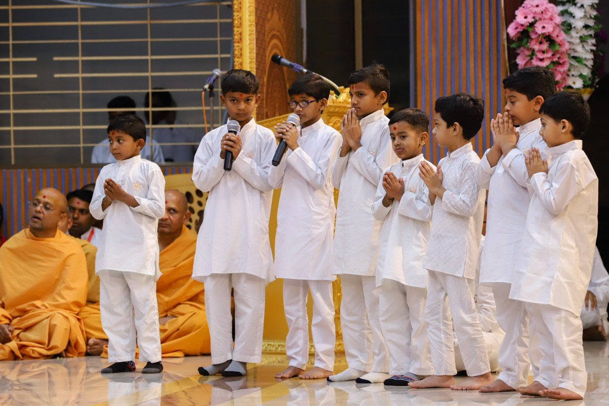 Children present mukhpath during Swamishri's puja