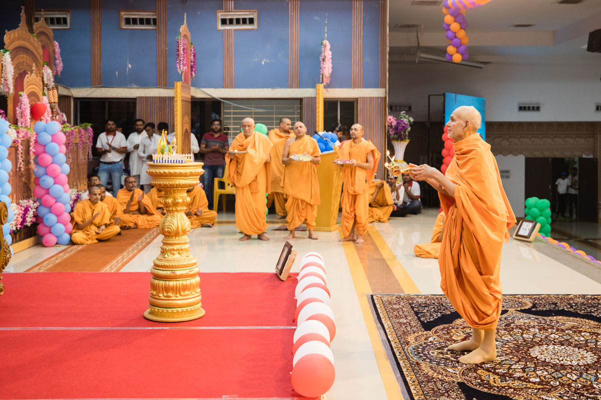 Swamishri and sadhus perform the evening arti