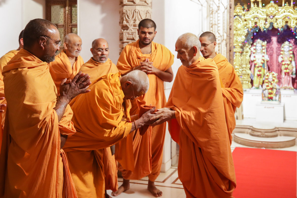 Swamishri blesses a sadhu beneath the mandir dome