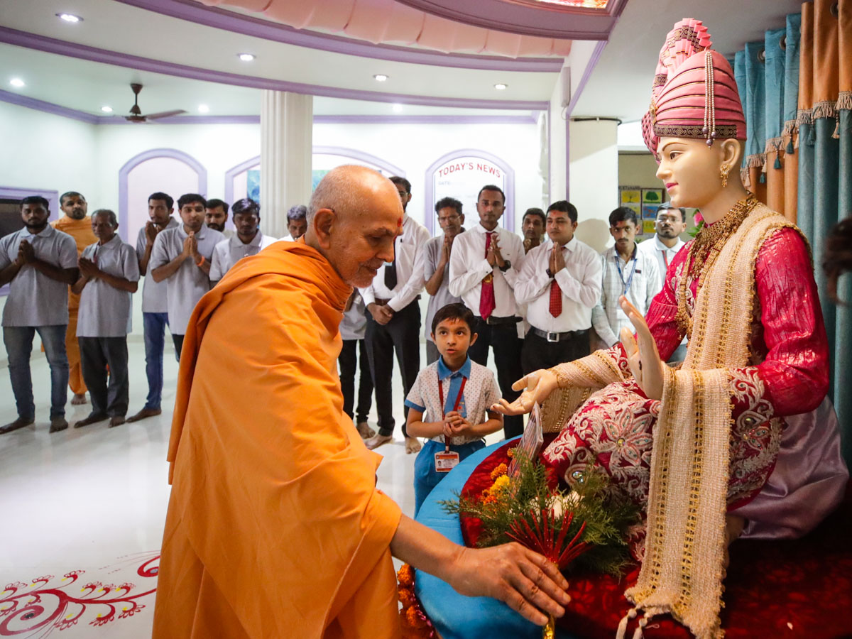 Swamishri offers flowers to Bhagwan Swaminarayan in the school