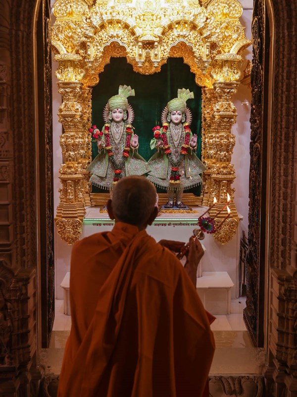 Swamishri performs the arti of Shri Akshar-Purushottam Maharaj