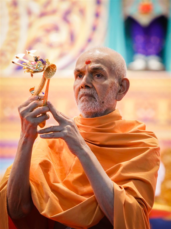 Swamishri performs the arti in the evening satsang assembly