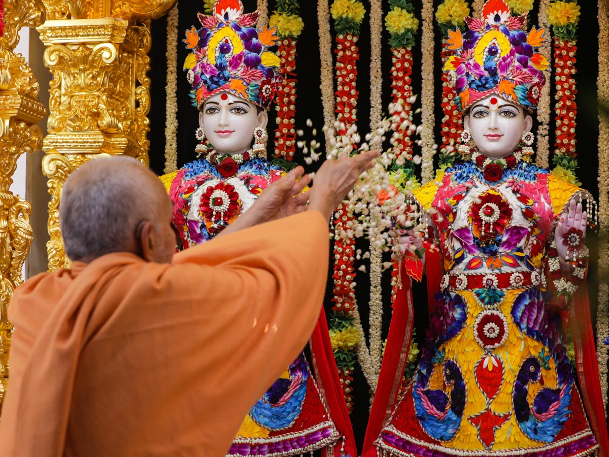 Swamishri showers flower petals on Shri Akshar-Purushottam Maharaj