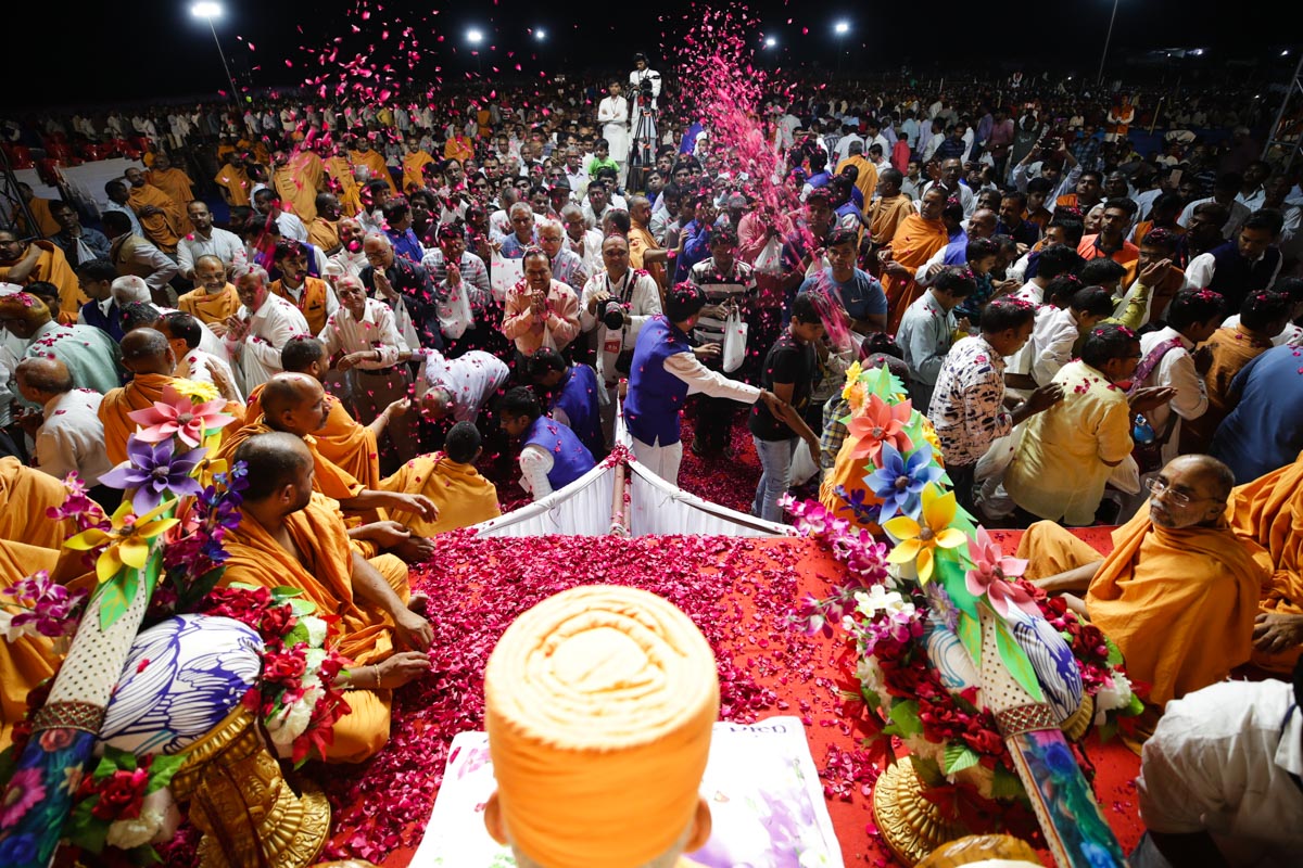 Devotees showered with sanctified flower petals as they pass by Swamishri