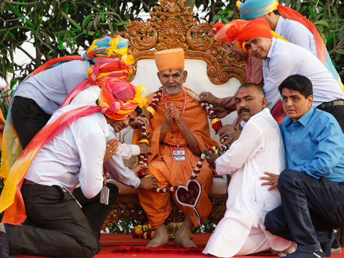 Vidyamandir staff honor Swamishri with a garland