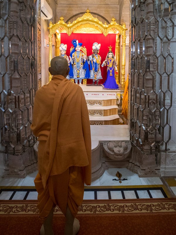 Swamishri engrossed in the darshan of Shri Varninath Maharaj and Shri Gopinath Dev