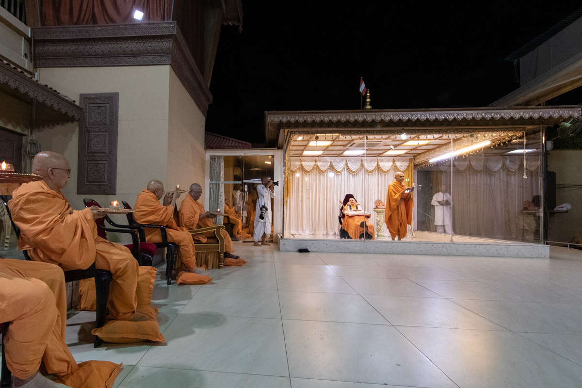 Swamishri and senior swamis perform the evening arti