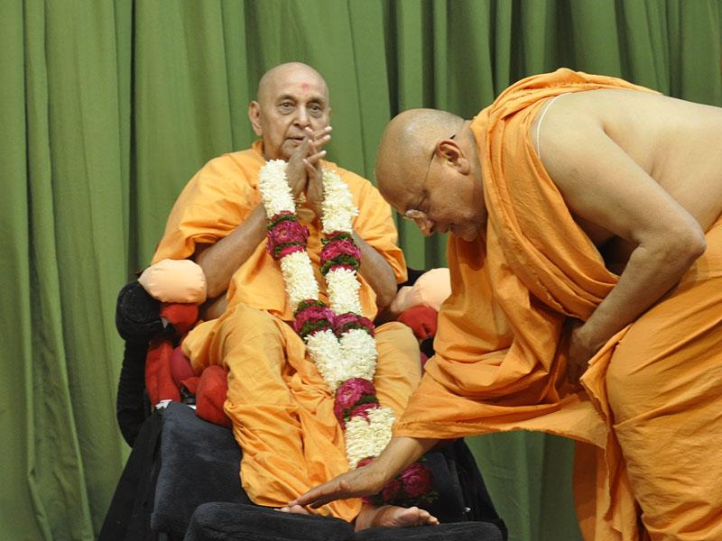 Senior sadhus welcome Swamishri with garlands