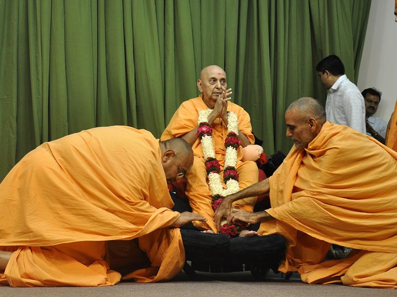 Senior sadhus welcome Swamishri with garlands