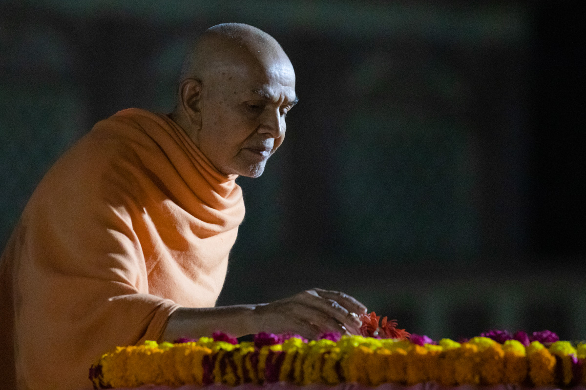 Swamishri places flowers at Brahmaswarup Pramukh Swami Maharaj's samadhi
