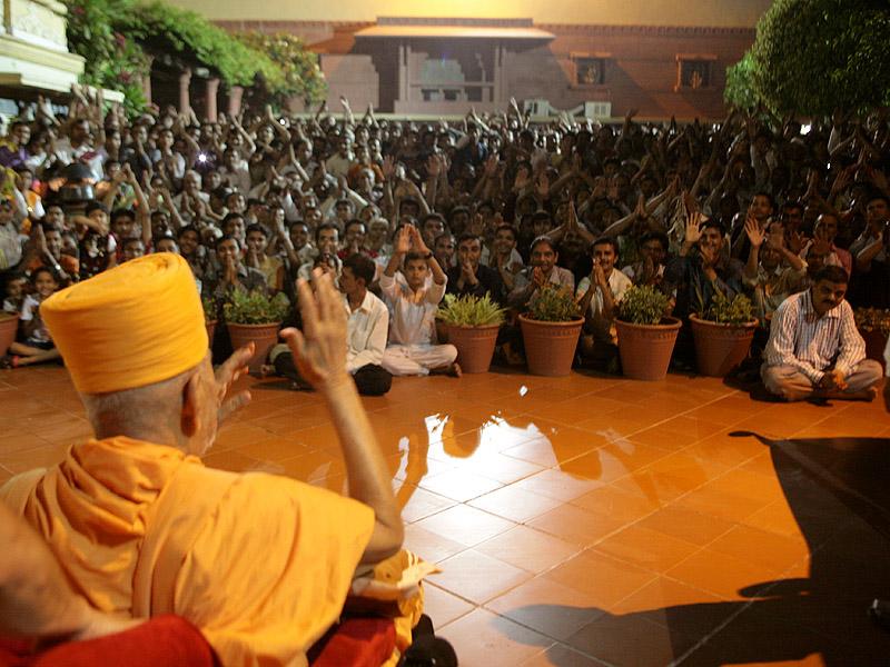 Swamishri arrives at BAPS Mandir. Devotees greet Swamishri on the mandir grounds