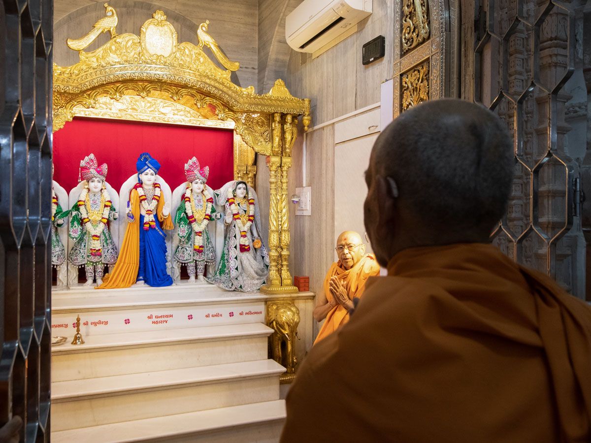 Swamishri engrossed in the darshan of Shri Dharmakul