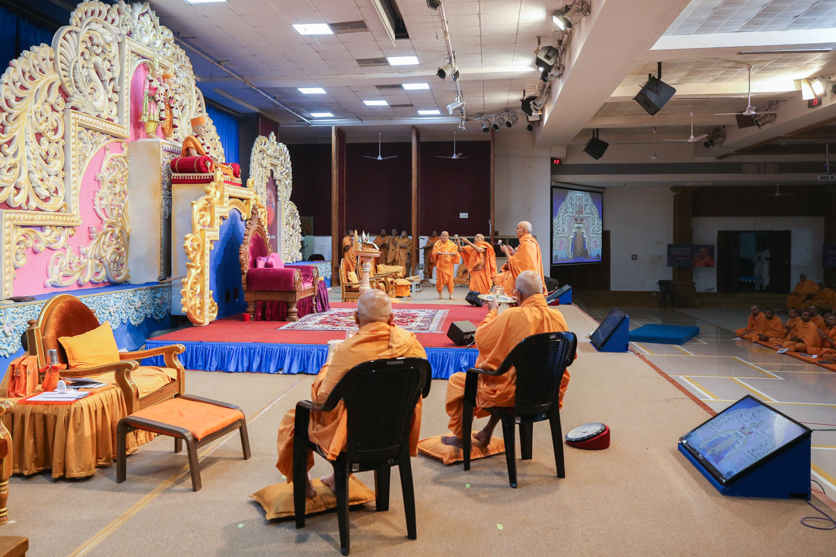 Swamishri and senior sadhus perform the arti during the Sant Shibir