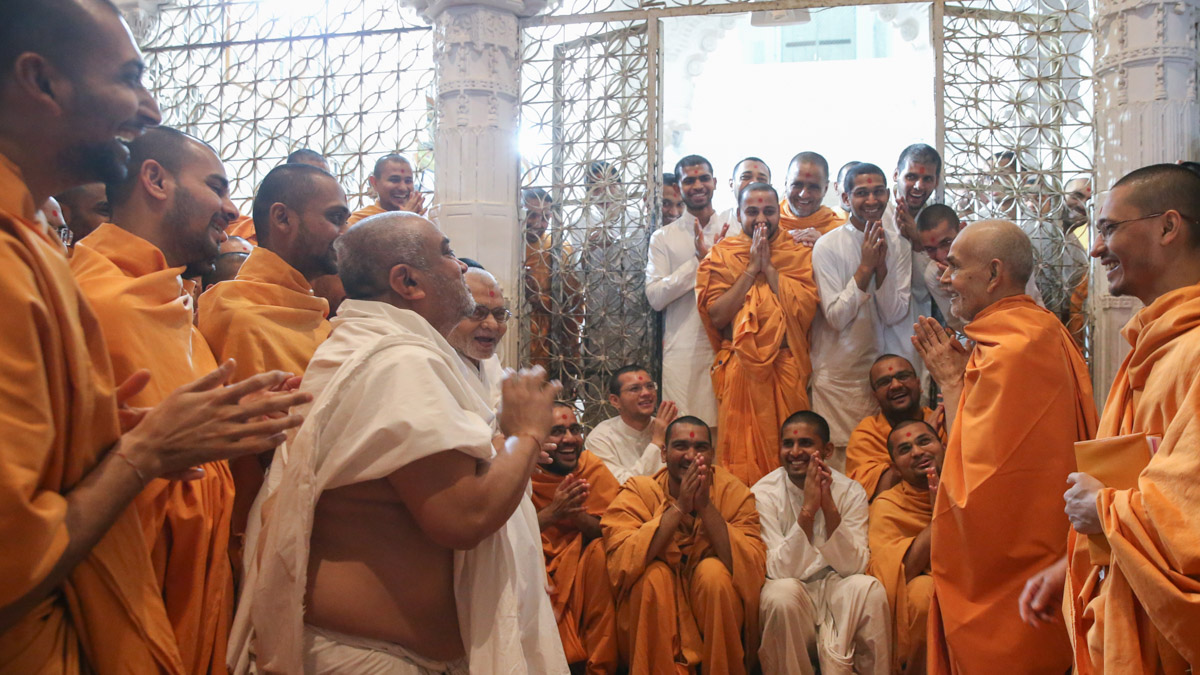 Swamishri shares a light moment with sadhus, parshads and sadhaks in the mandir pradakshina
