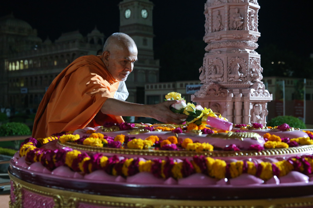 Swamishri places flowers at Brahmaswarup Pramukh Swami Maharaj's samadhi