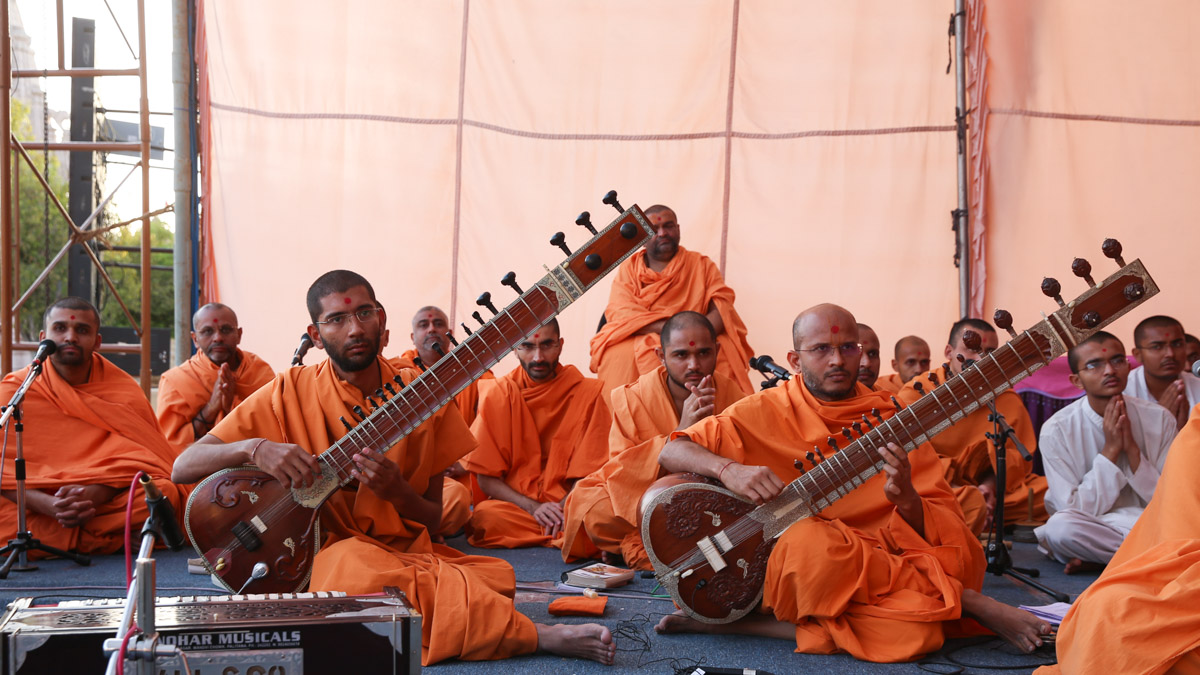 Sadhus play sitar before Swamishri