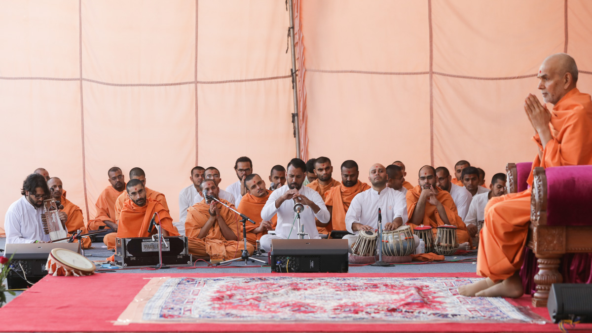 Devotees play musical instruments before Swamishri