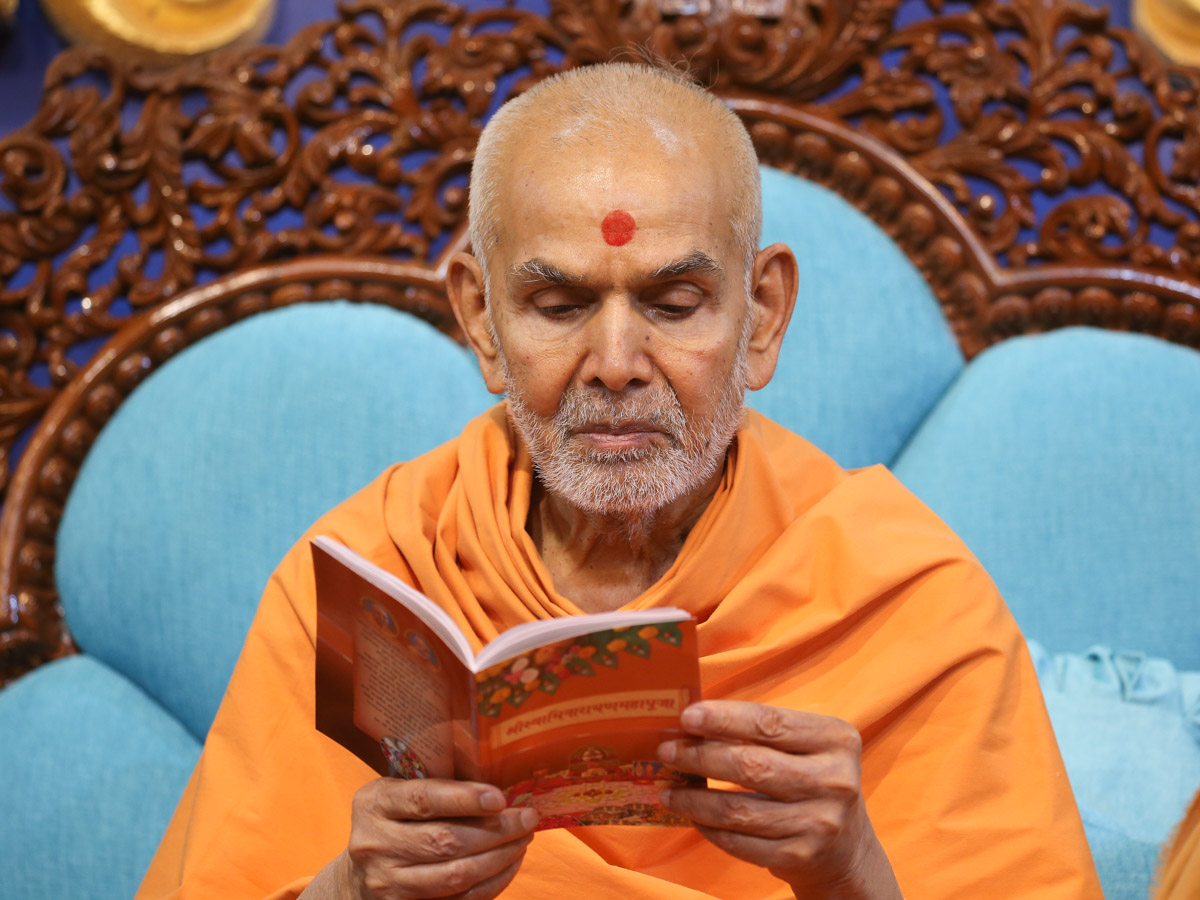 Swamishri sanctifies a 'Shri Swaminarayan Mahapuja' book