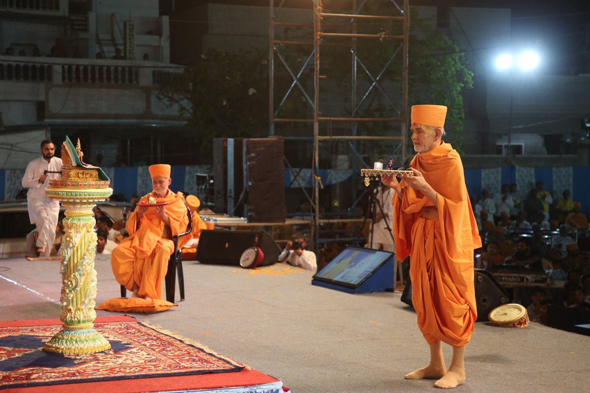 Swamishri and Bhagwatpriya Swami perform the evening arti