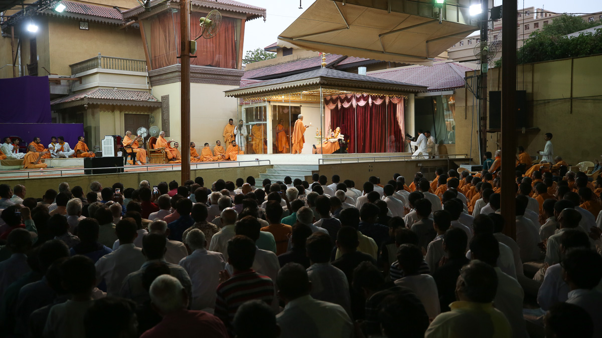 Swamishri and senior sadhus perform the evening arti