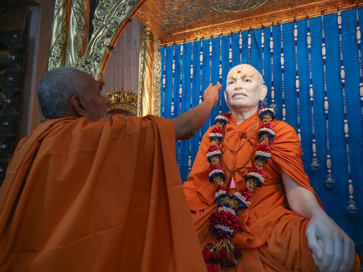 Swamishri applies chandan archa on Brahmaswarup Shastriji Maharaj