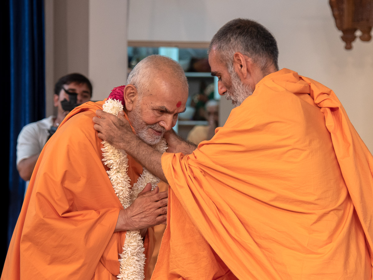 Anandswarup Swami welcomes Swamishri with a garland