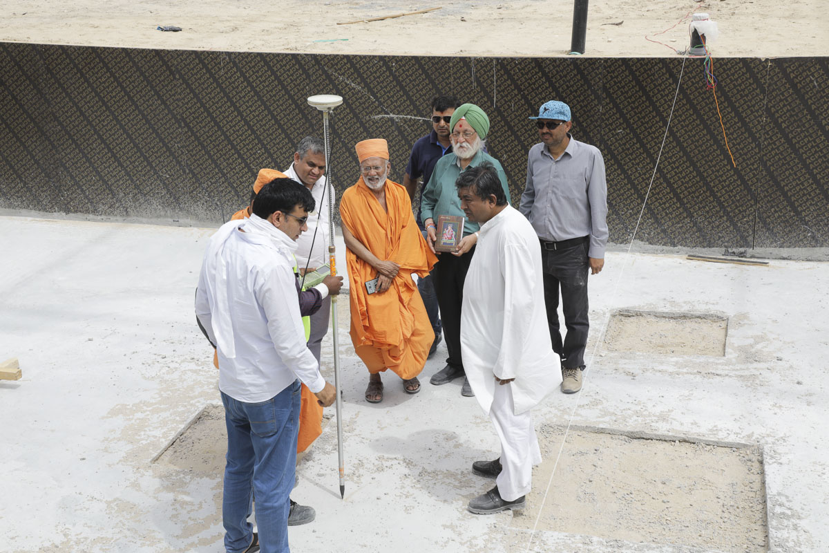 Sadhus and volunteers prepare the foundations