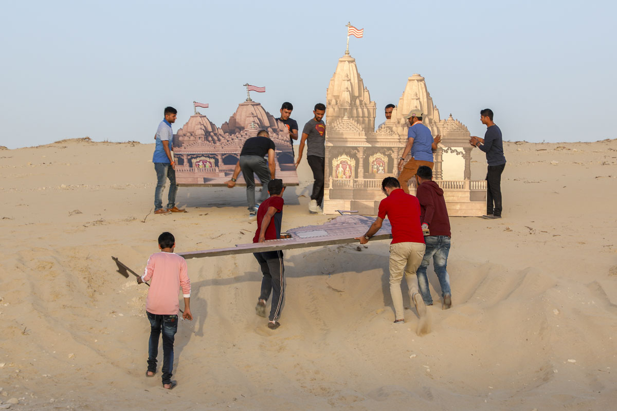 Volunteers place decorations on the mandir site