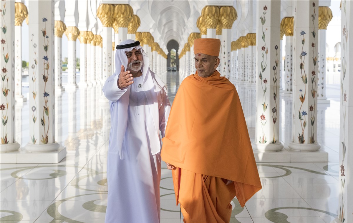 HE Sheikh Nahyan bin Mubarak Al Nahyan and HH Mahant Swami Maharaj stand in the corridor of 1,096 pillars