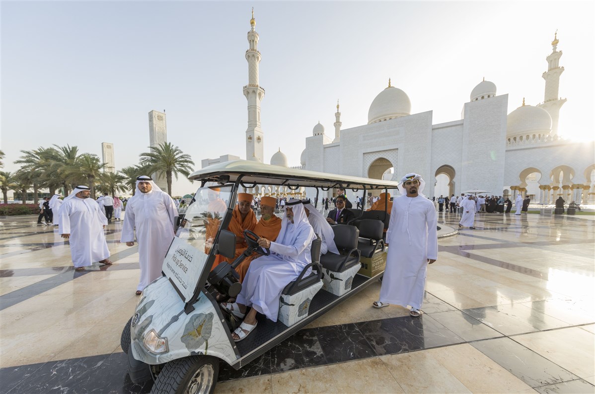 HE Sheikh Nahyan bin Mubarak Al Nahyan drives HH Mahant Swami Maharaj in a golf car to view the Martyr’s Memorial