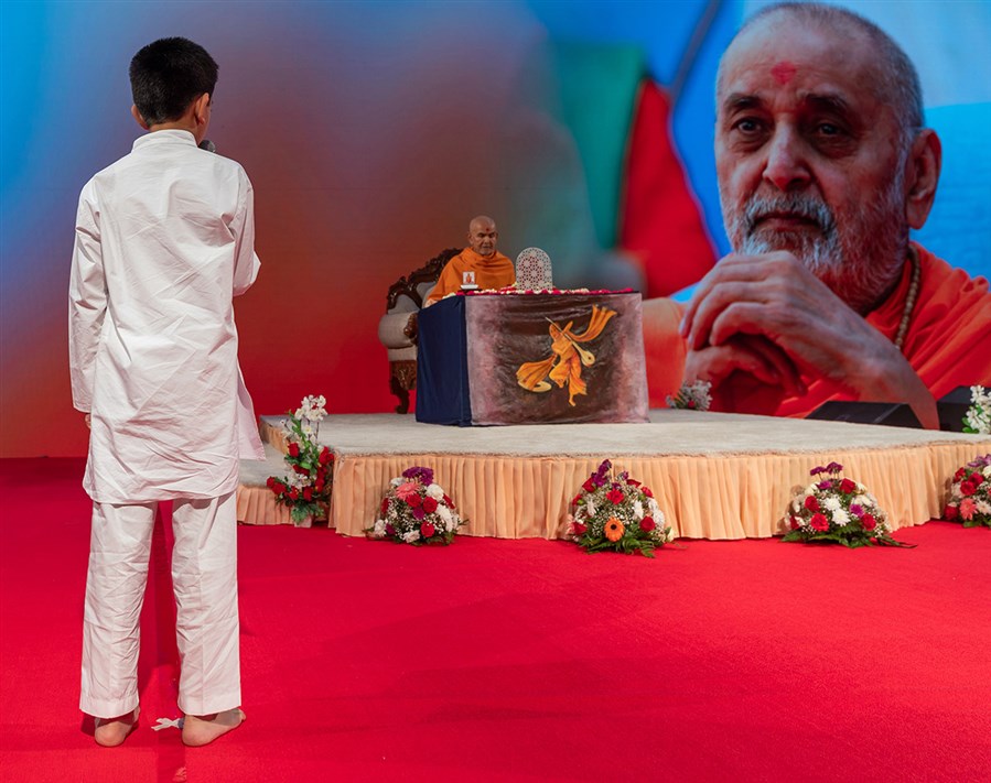 A child recites scriptural passages in Swamishri's puja