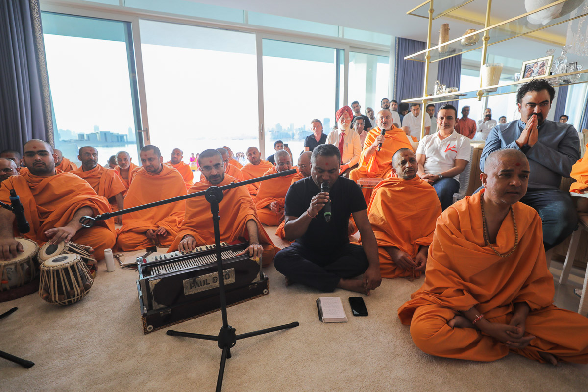 A devotee sings a kirtan in Swamishri's morning puja