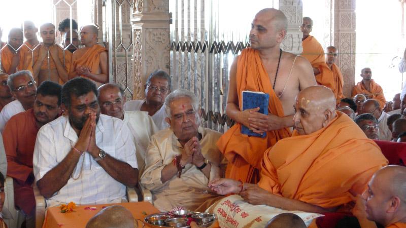   Swamishri and devotees perform pratishtha rituals of arti and mantra pushpanjali