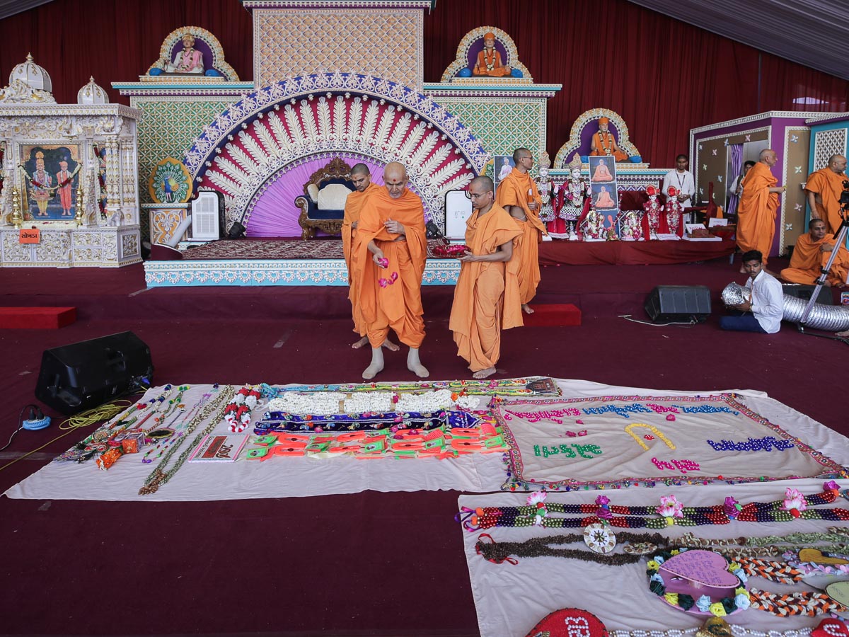 Swamishri sanctifies garlands and shawls made by devotees