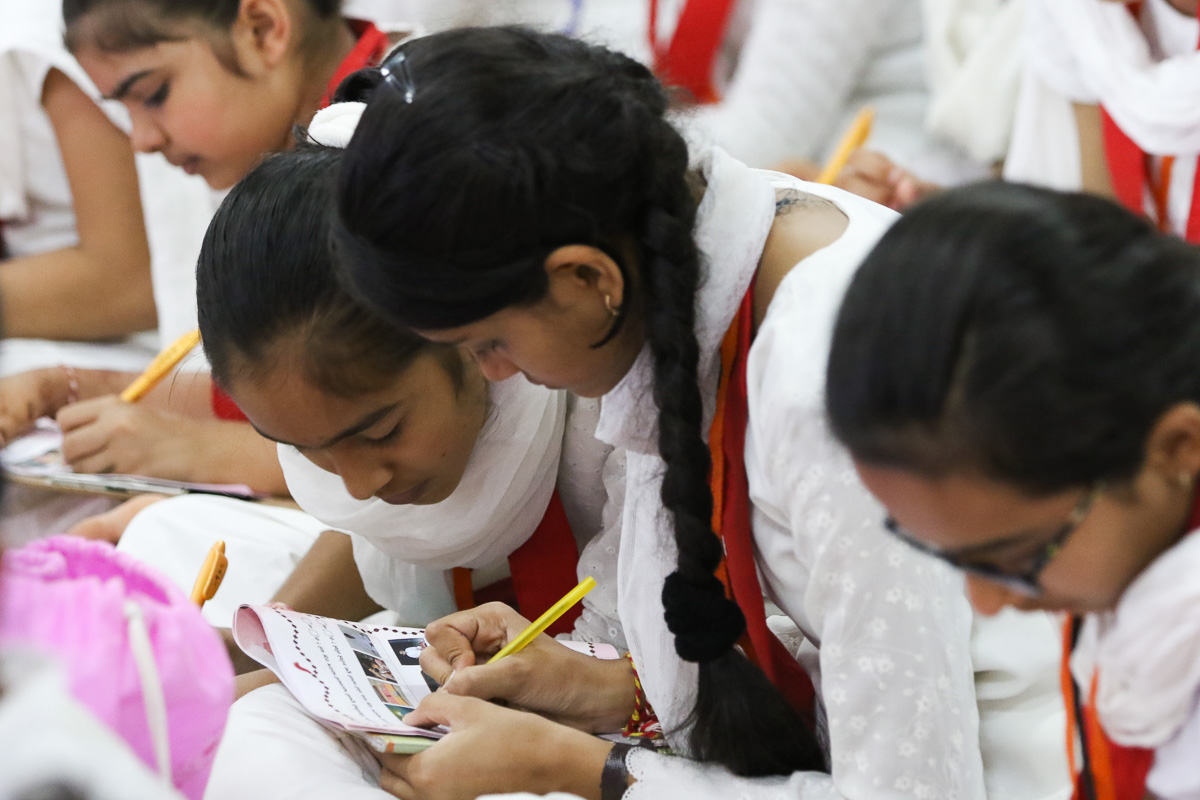 Balikas write notes during a shibir session