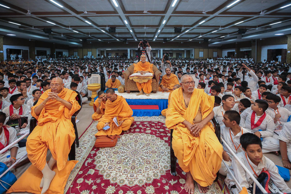 Swamishri, Pujya Bhaktipriya Swami (Kothari Swami) and Pujya Tyagvallabh Swami view the program