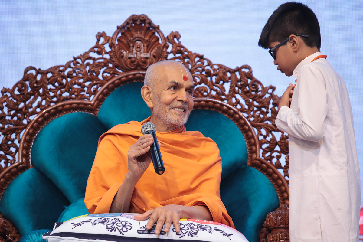 A child converses with Swamishri