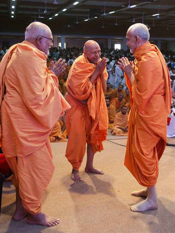 Pujya Kothari Swami and Pujya Tyagvallabh Swami greet Swamishri with 'Jai Swaminarayan'