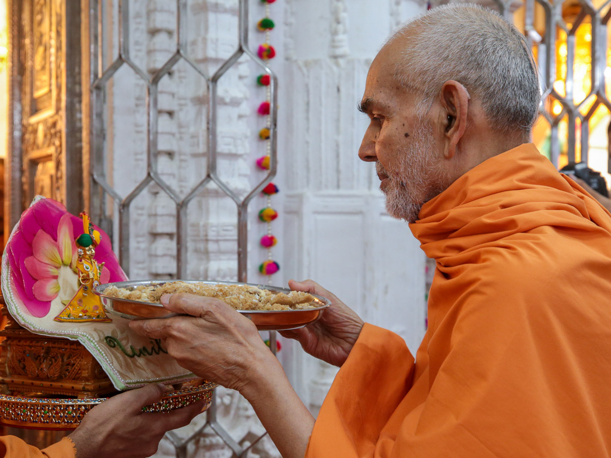 Swamishri offers shiro to Shri Harikrishna Maharaj