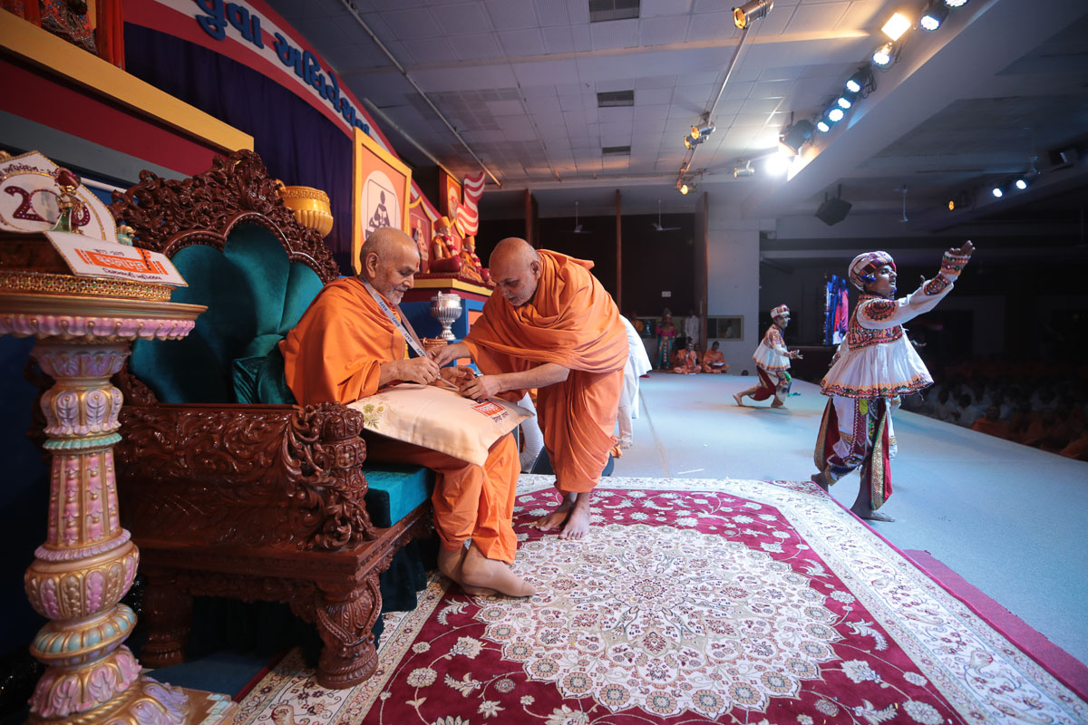 Yagnapriya Swami presents an adhiveshan ID card to Swamishri