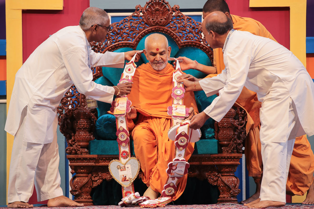 Karyakars honor Swamishri with a garland