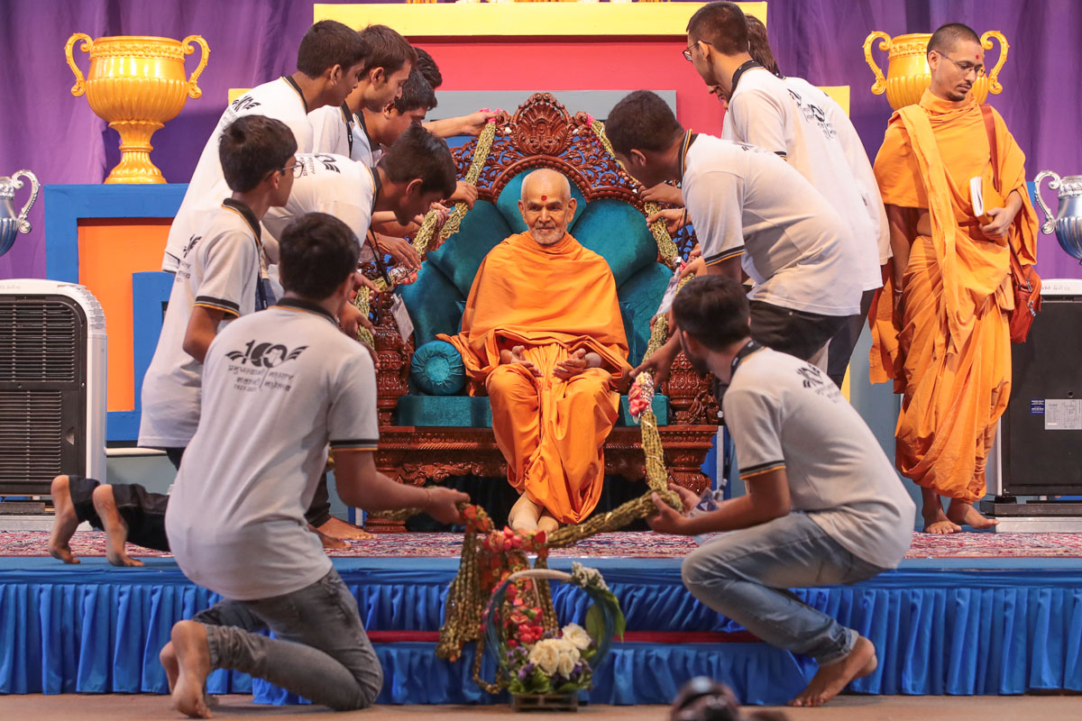 Youths honor Swamishri with a garland