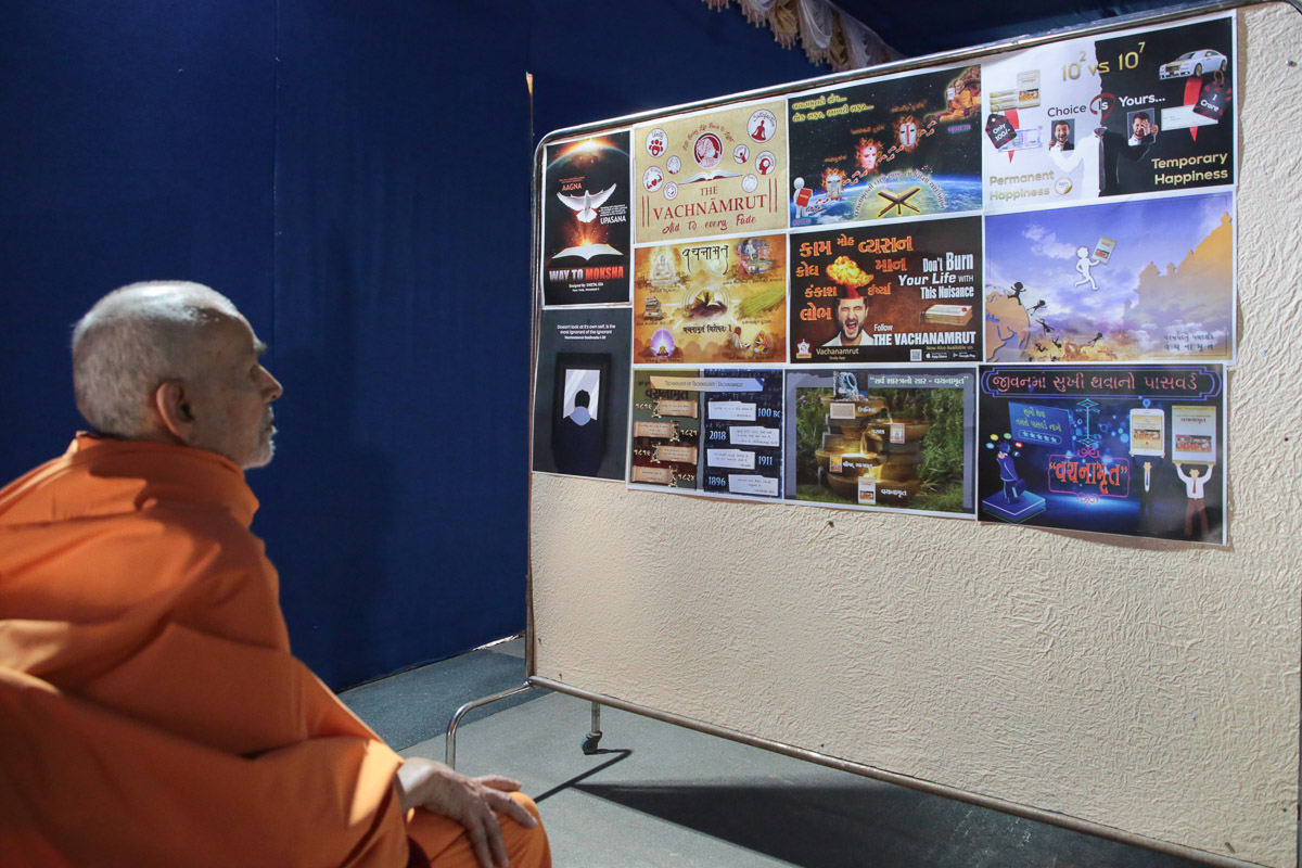 Swamishri observes posters created by youths