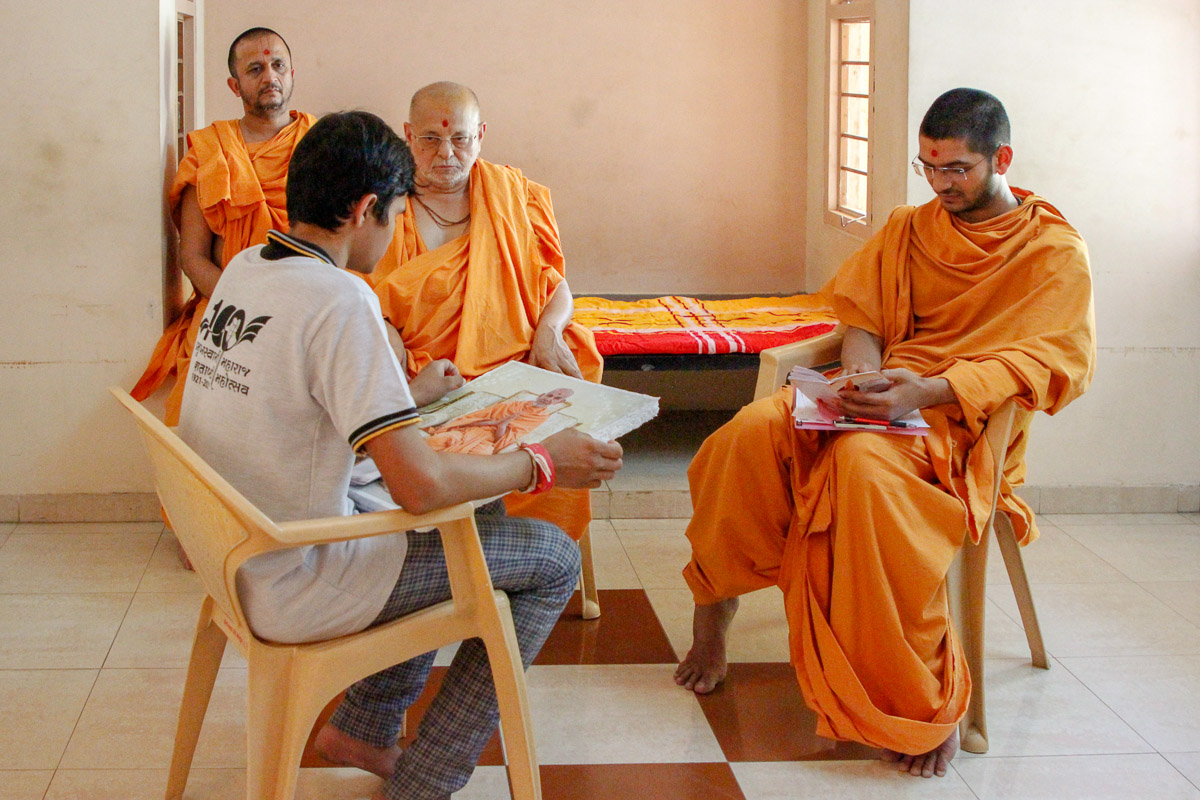 Pujya Ishwarcharan Swami observes a youth participating in the Vachanamrut Mukhpath competition