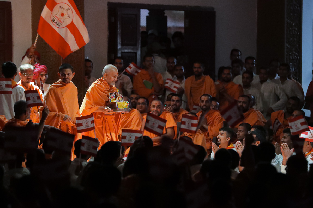 Youths welcome Swamishri by waving BAPS flags