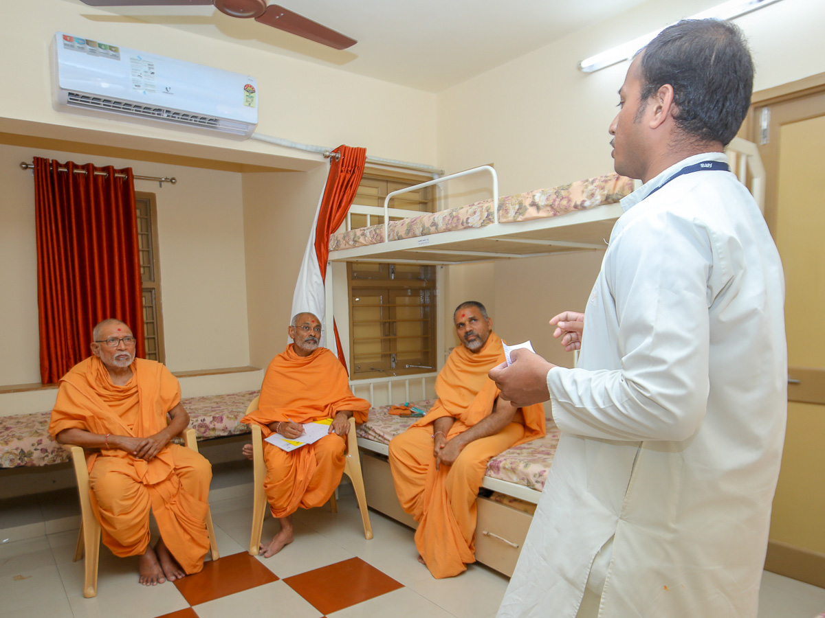 Pujya Kothari Swami observes a youth participating in the Speech competition