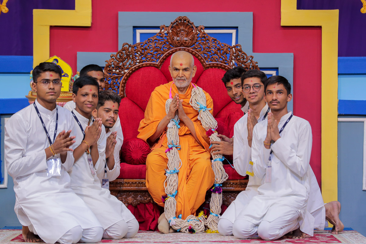 Youths honor Swamishri with a garland