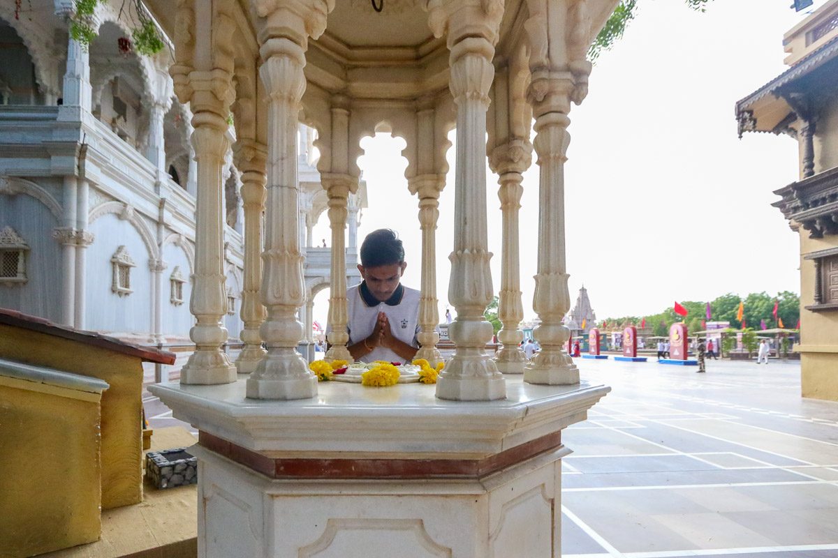 A youth doing darshan of the holy charanarvind of Bhagwan Swaminarayan
