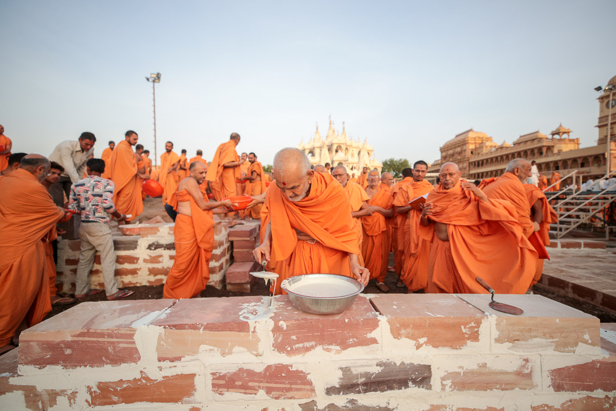 Swamishri performs seva