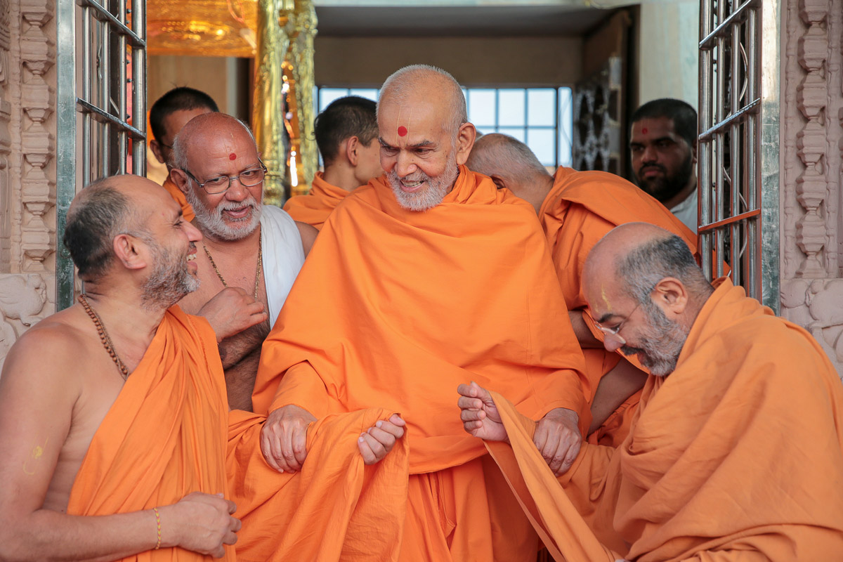 Swamishri shares a light moment with Narayancharan Swami and Dharmacharan Swami